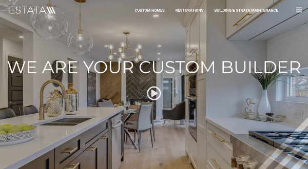 Modern kitchen and dining area with white cabinetry, gold fittings, pendant lights, and a dining table with chairs. Bold text overlays the image stating, WE ARE YOUR CUSTOM BUILDER by Loomo Marketing.
